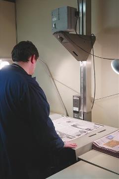 man standing over a microfilm