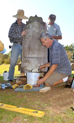 volunteers restoring a headstone