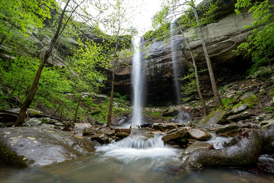 Sweden Creek Waterfall on an overcast day surrounded by greenery.