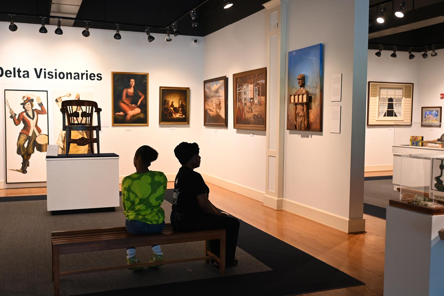 Two women sitting on a bench inside the Delta Cultural Center exhibit.