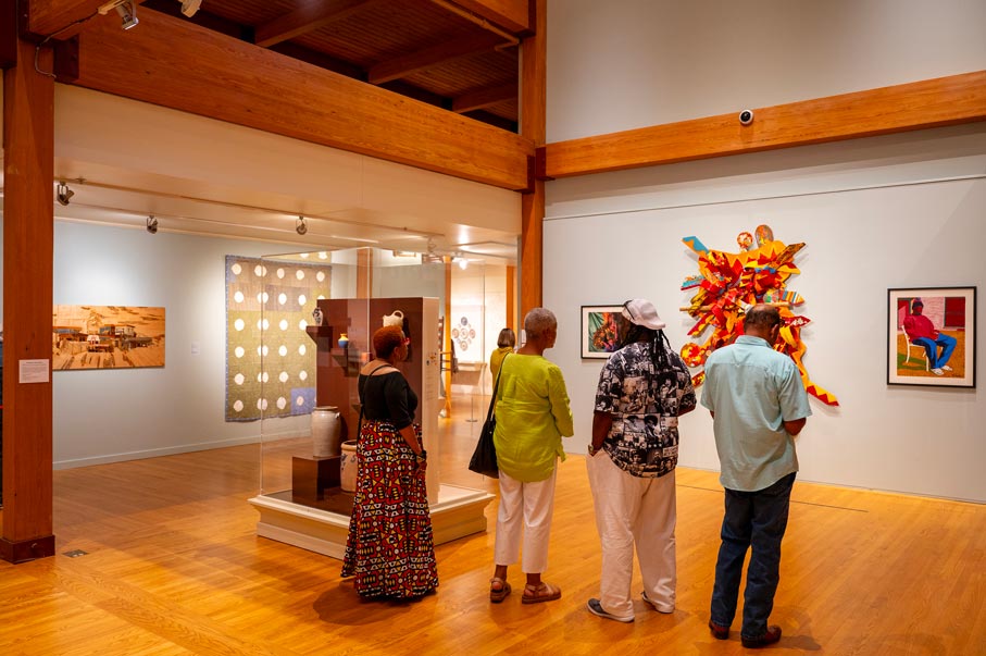 Four museum visitors admire art in the Historic Arkansas Exhibit.