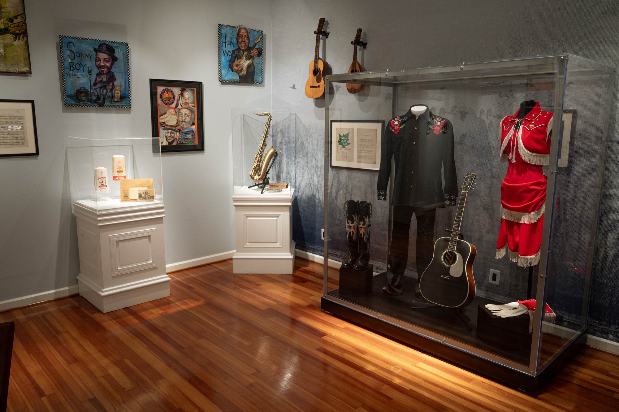 Museum room containing musical instruments, music themed artworks, and stage uniforms.