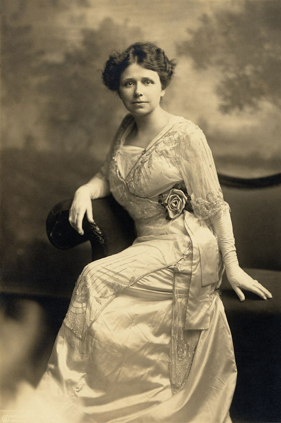 Hattie Caraway in sepia tone posing on a couch in a long pale dress.
