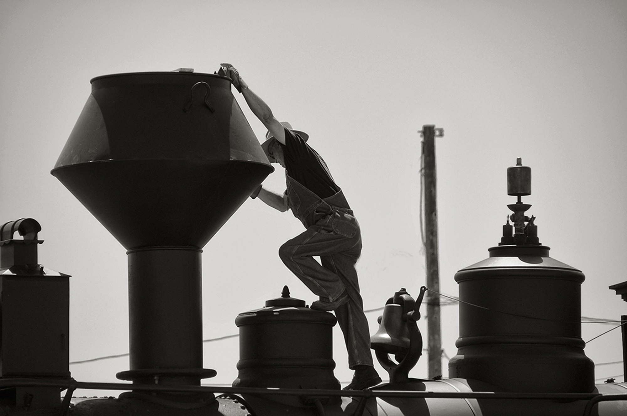 black and white photo of person in overalls with geometric instruments