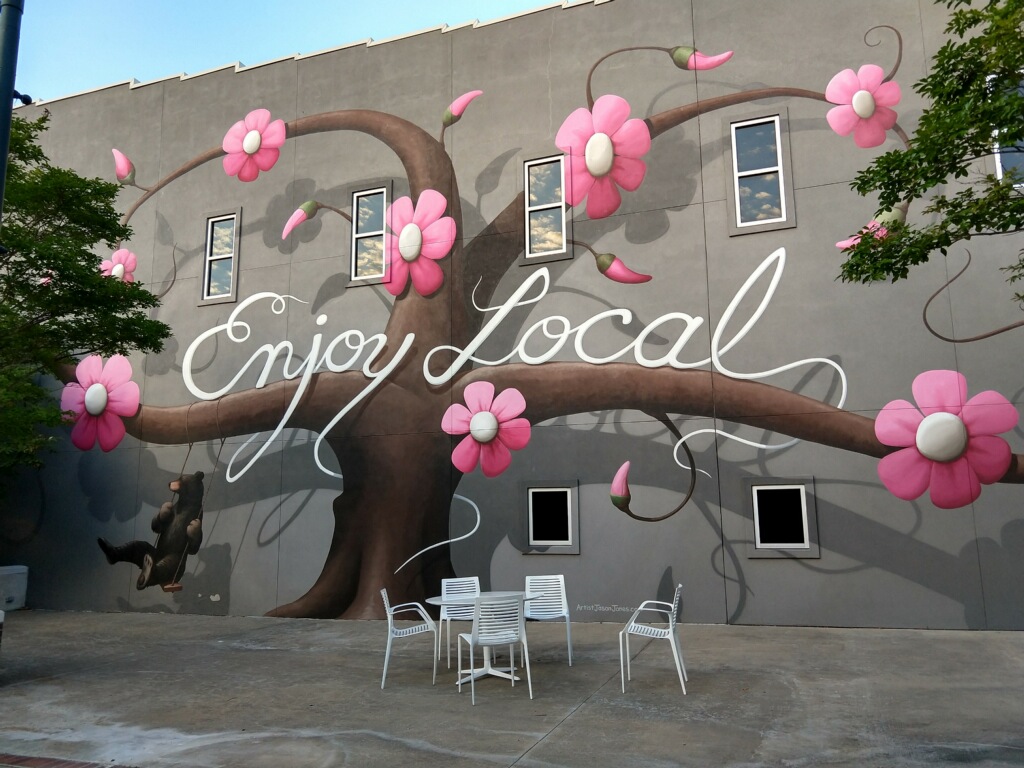 mural of tree with flowers and bear swinging 