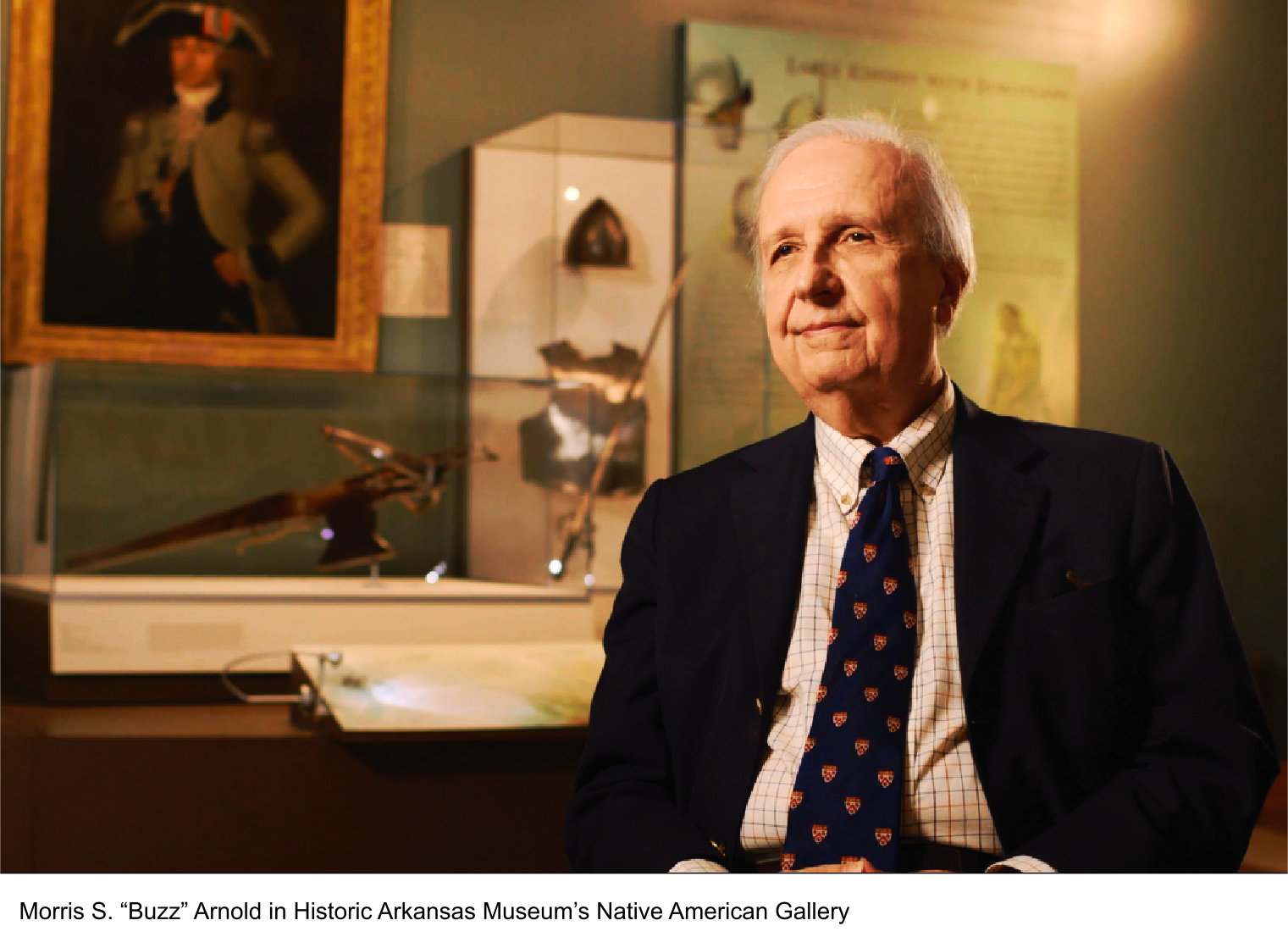 historic gallery with man sitting in front of with jacket and tie