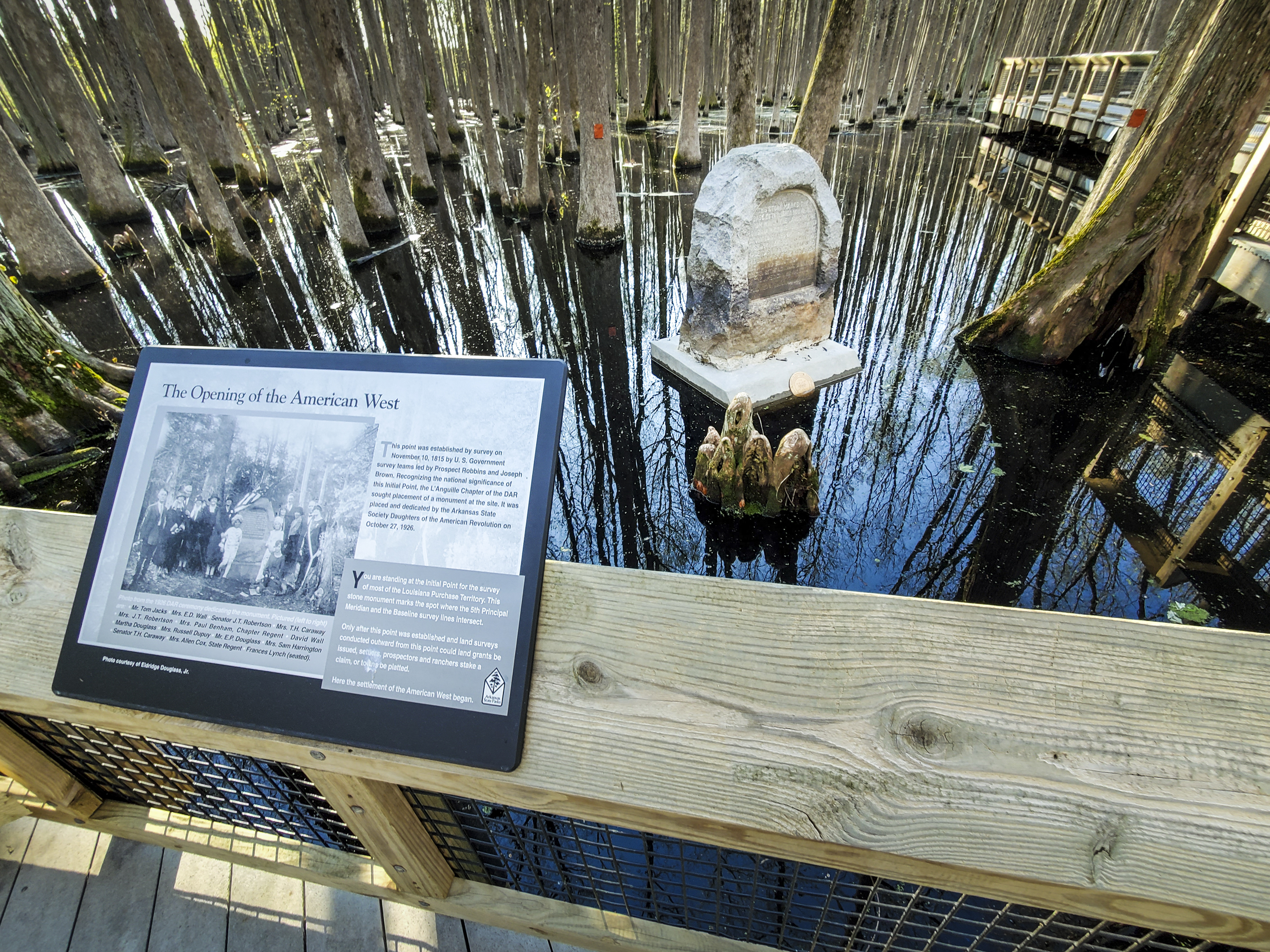 A wooden boardwalk leads visitors to the historic marker within the Louisiana Purchase State Park and Natural Area