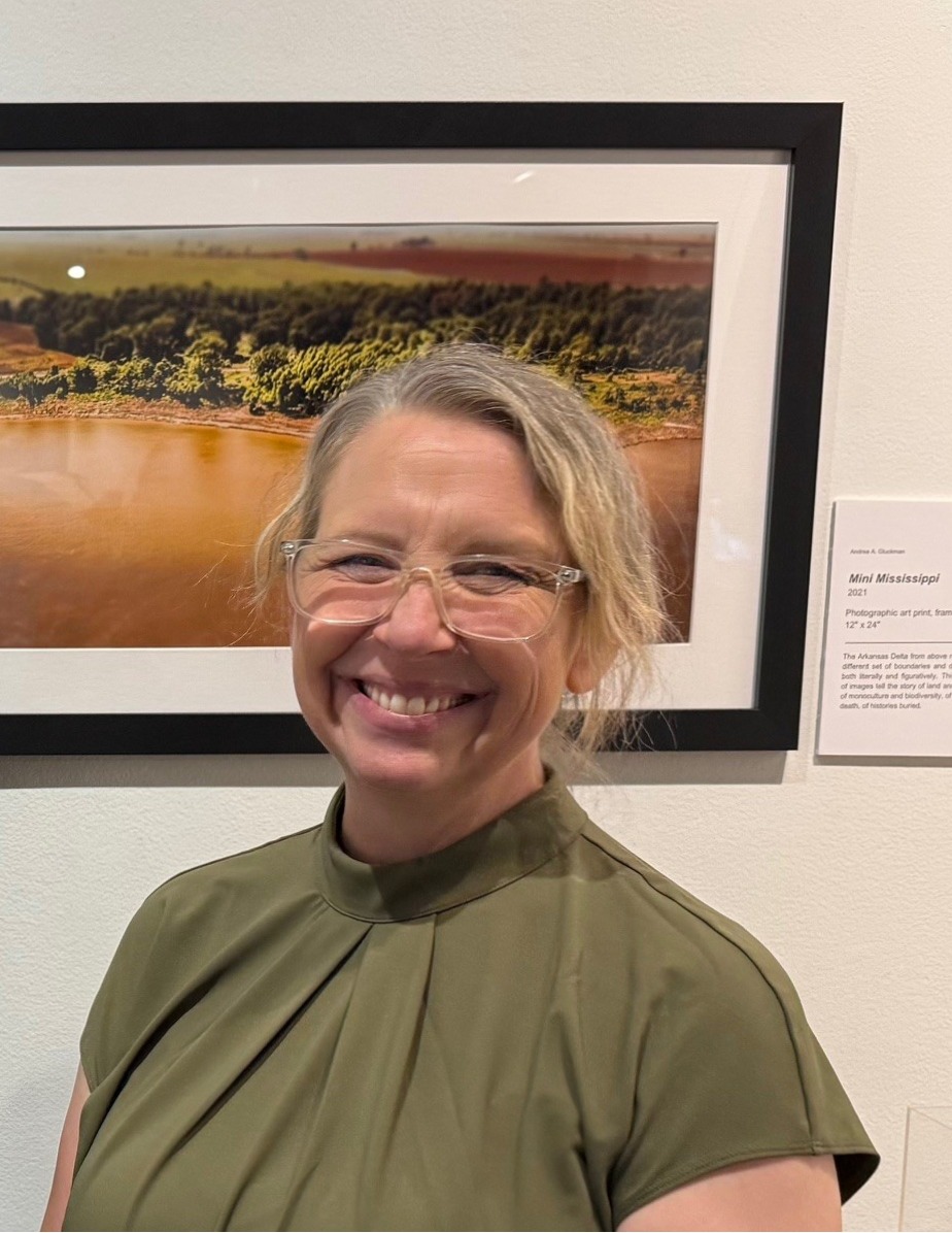 Artist Andrea A. Gluckman posing in front of one of her works.