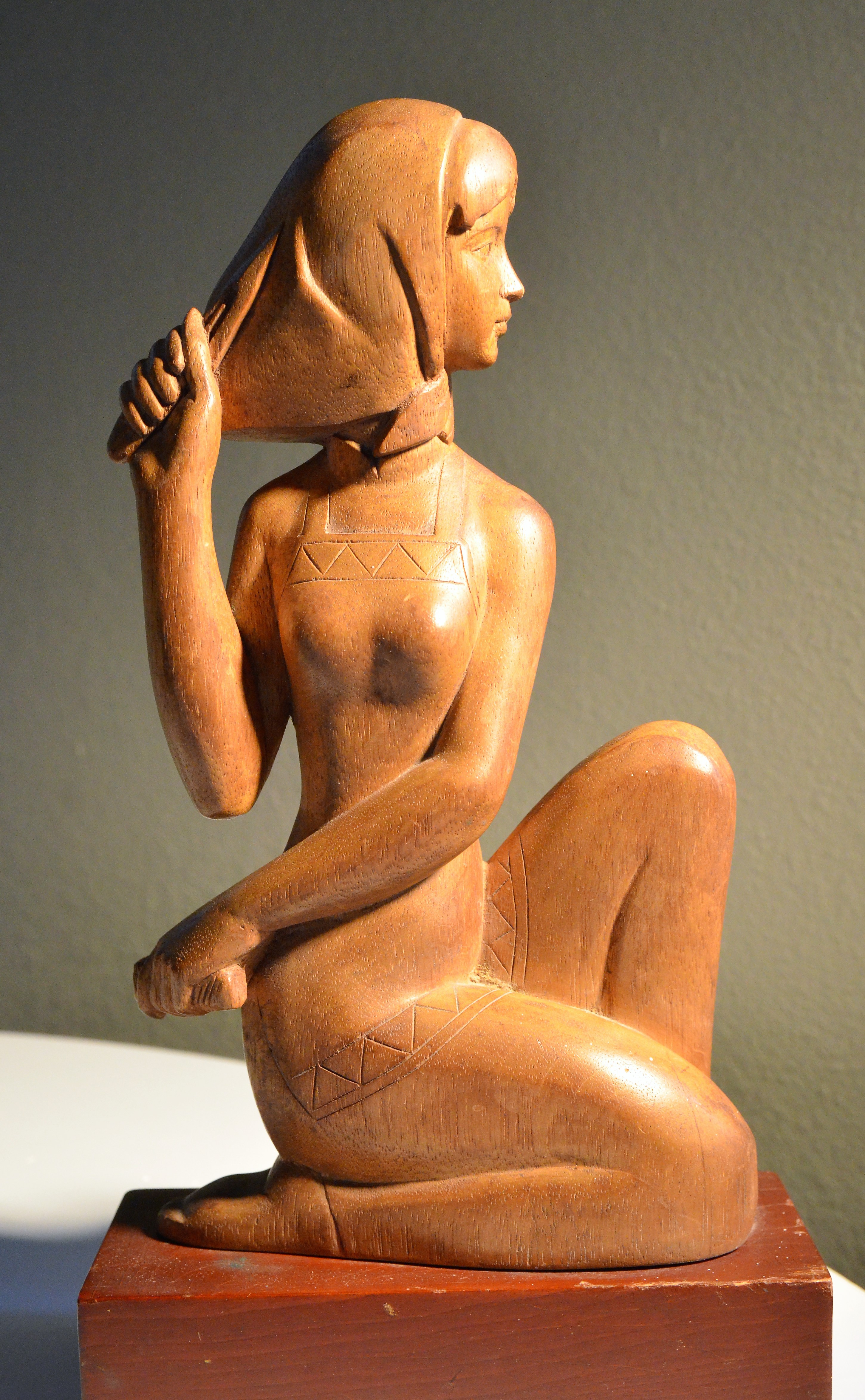 wooden statue of woman holding her hair