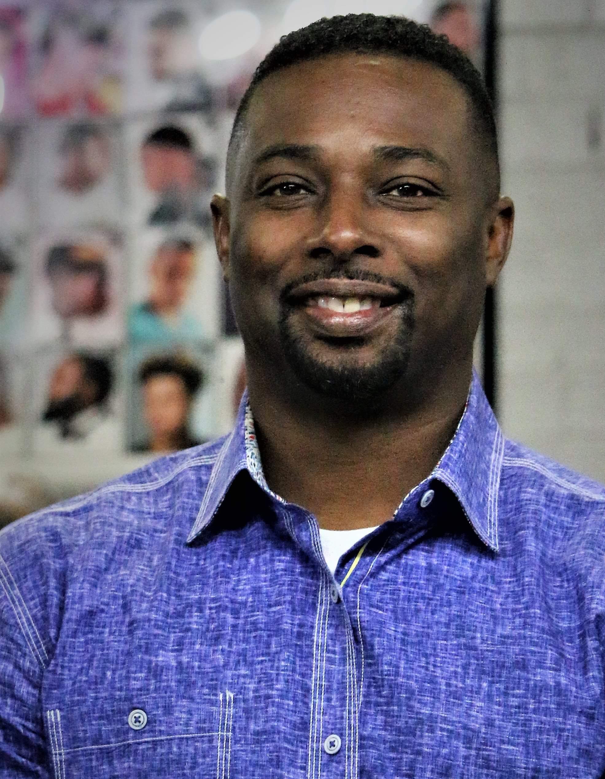 headshot of man smiling with button-up shit with collar