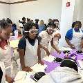 Studentsdressedinapronsandgogglesmixingablackliquid