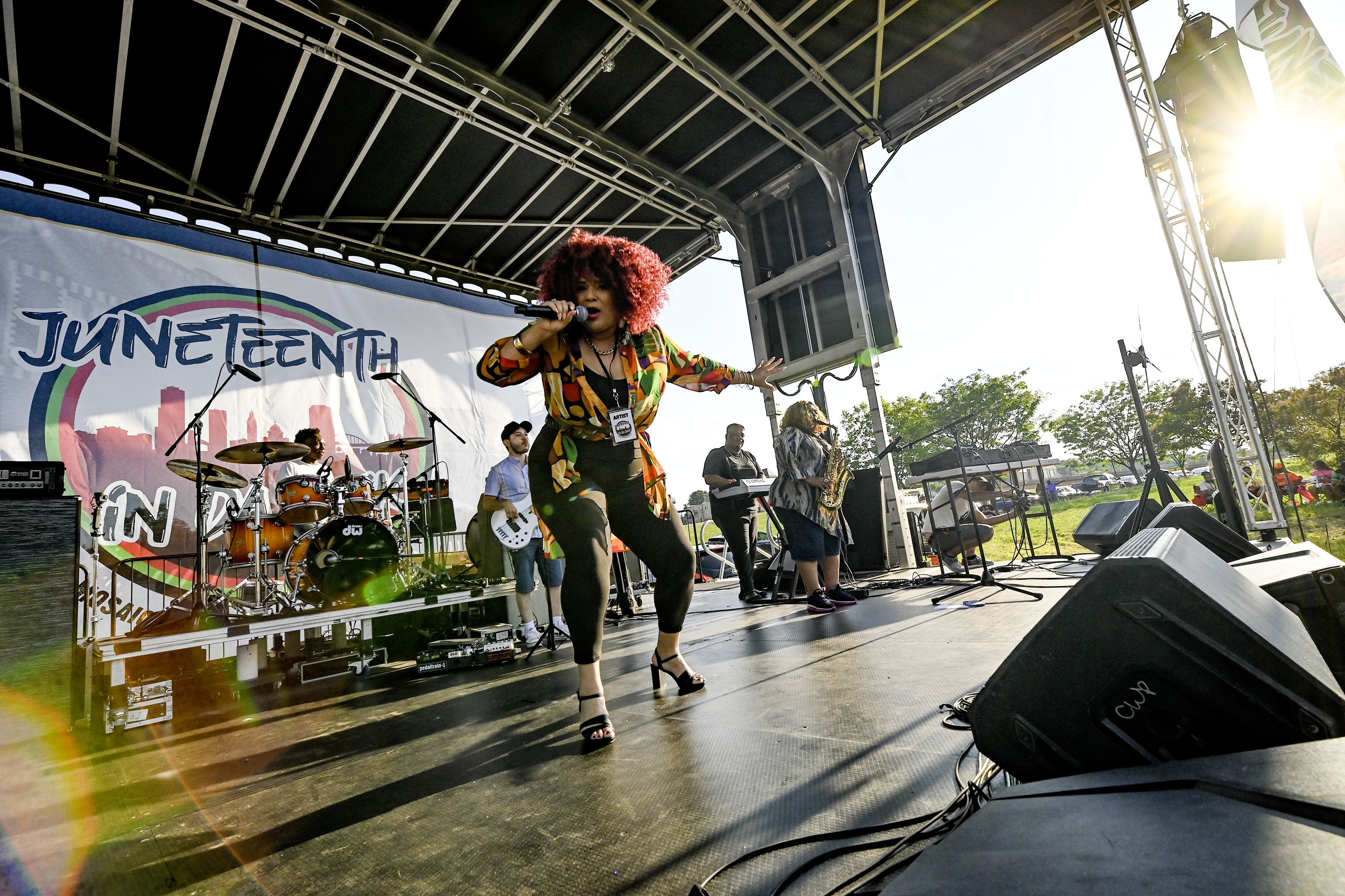 Womansingingonstagewithalivebandbehindher