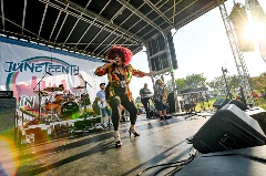 Womansingingonstagewithalivebandbehindher