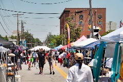 Peoplewalkingalongastreetwithmarketbooths