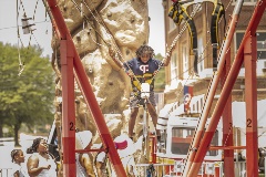 Childonabunjeerideinfrontofafakerockwall