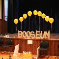 Booseumletteringstandinguponastagewithballoonsandablow-upjack-o-lantern