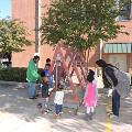 kidsandadultsoutsidelookingatchickensinaA-shapemobilecoop