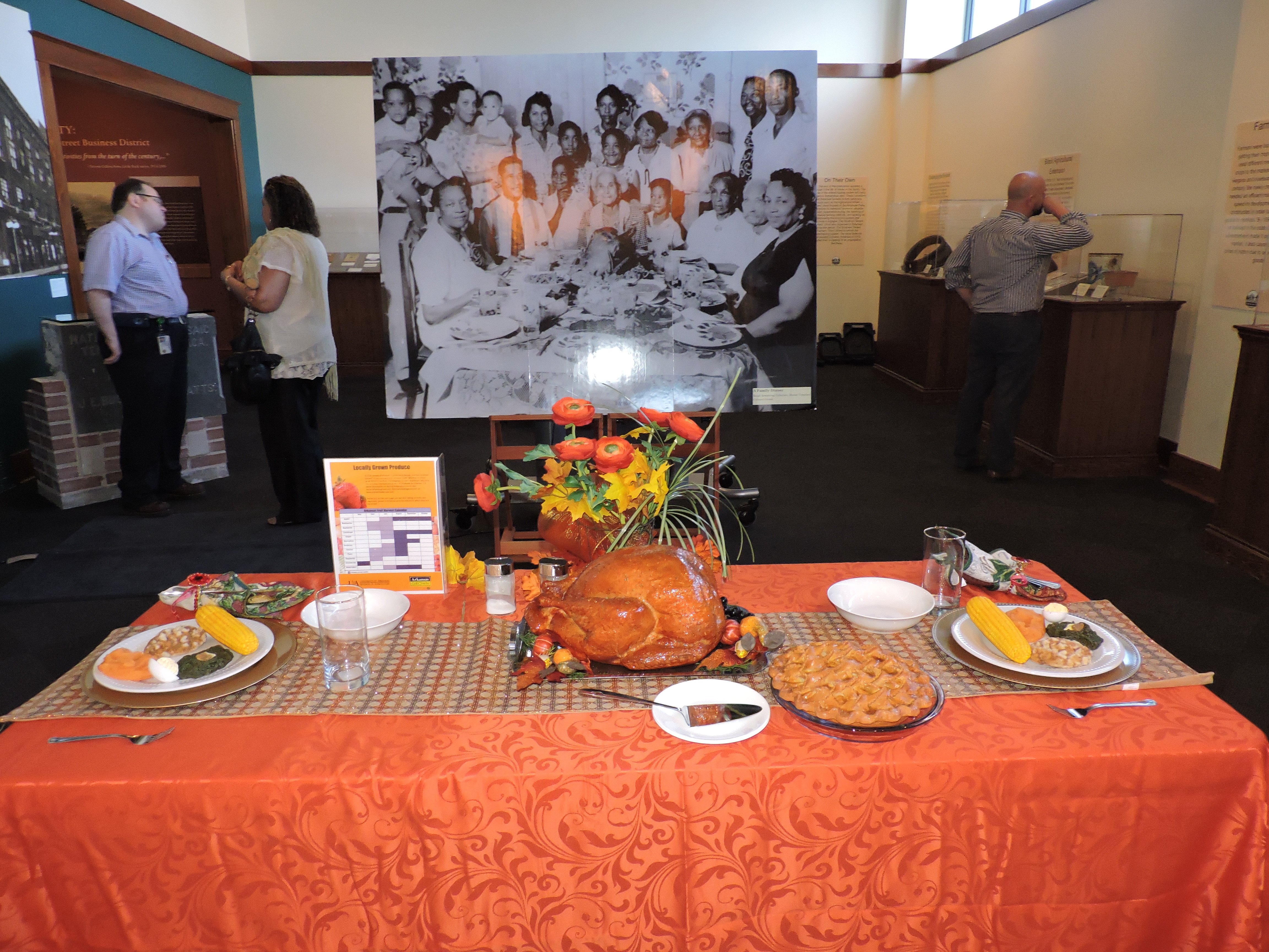 plasticfooddisplayofaholidaymealontableinfrontofblackandwhitegroupphotoaspartofexhibit