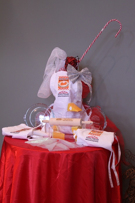 roundtablewithredtableclothanddisplayofbakingapronrollingpinpiedishesbowsandcandycanedecoration