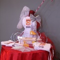 roundtablewithredtableclothanddisplayofbakingapronrollingpinpiedishesbowsandcandycanedecoration