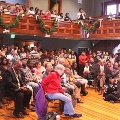 largecrowdofpeoplesittinginchairsinroomlookinginonedirection