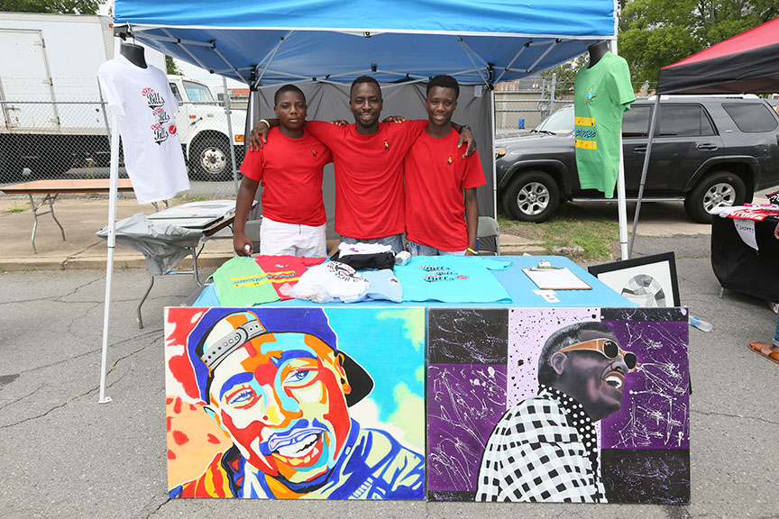 youngmeninredt-shirtsstandingbehindtablewithcolorfulgraphicartandt-shirts