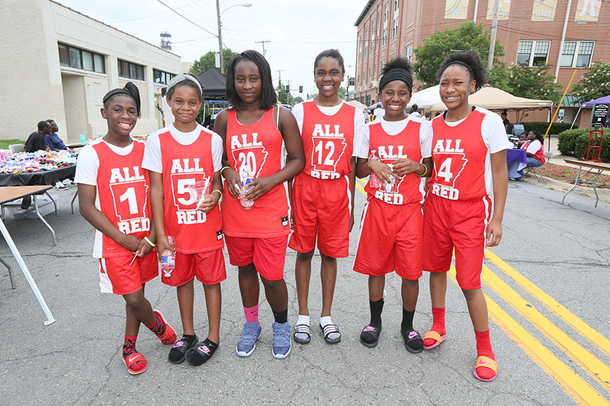 girlsinredbasketballuniformsandsandalssmiling