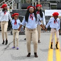 girlsinkhakipantsbluebutton-upshirtsandredscarfsandberetswearingsocksanddancing