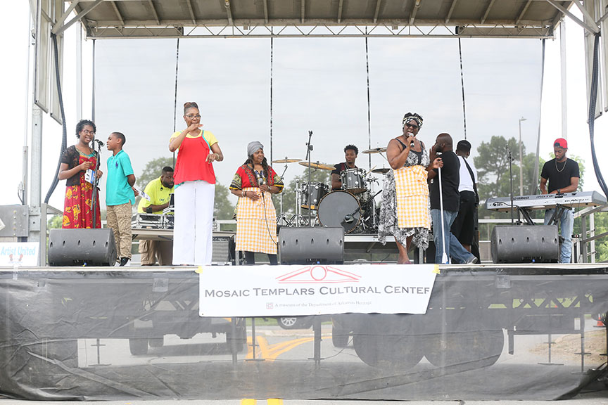 variouspeopleonstagetalkingsingingsigningandplayingdrumsandkeyboard
