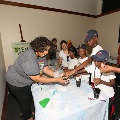 womanhelpingchildrendocraftsatfestivaltable