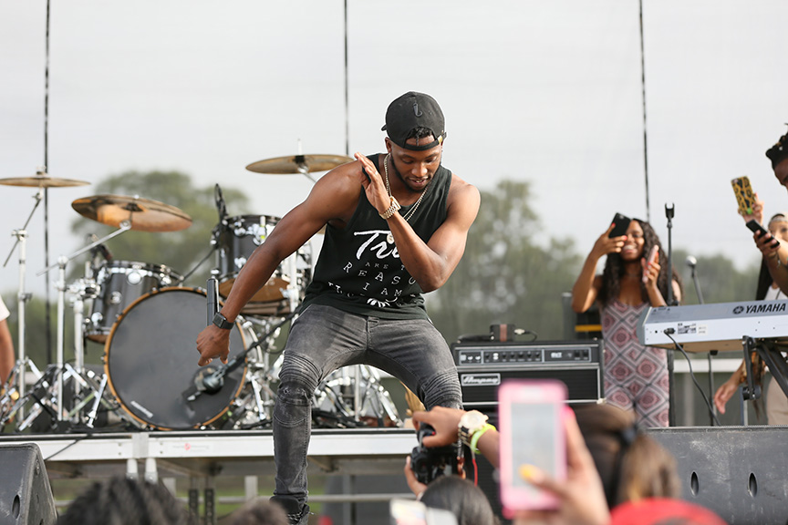 maninblackbaseballcaptanktopandgrayjeansdancingonstage