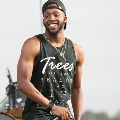 maninblacktanktopholdingmicrophone