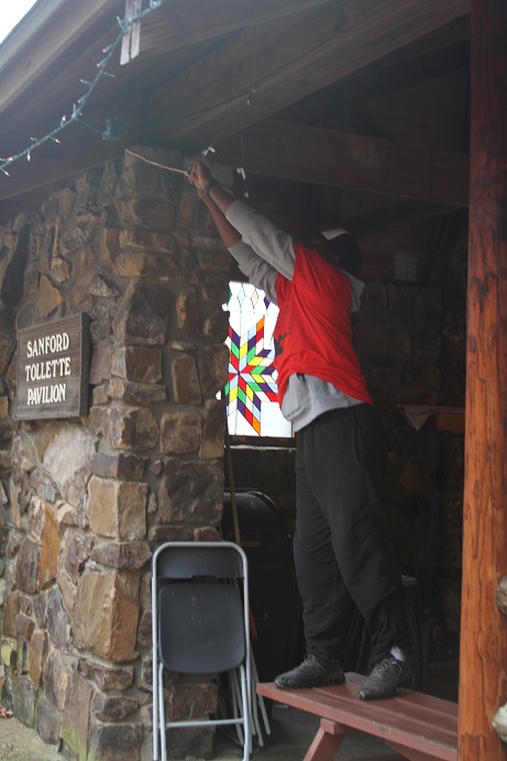 personhangingdecorativelightsonstonebuilding