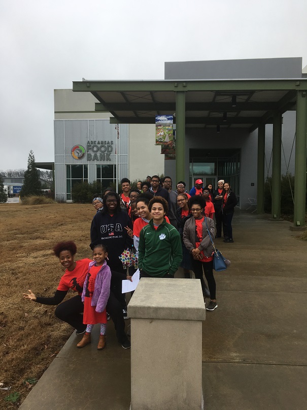 groupofyoungadultsandkidsoutsidearkansasfoodbankbuilding
