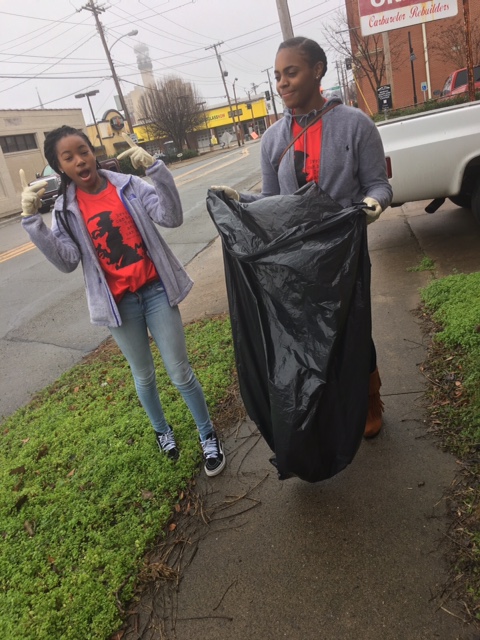 girlswithtrashbagstandingonsidewalk