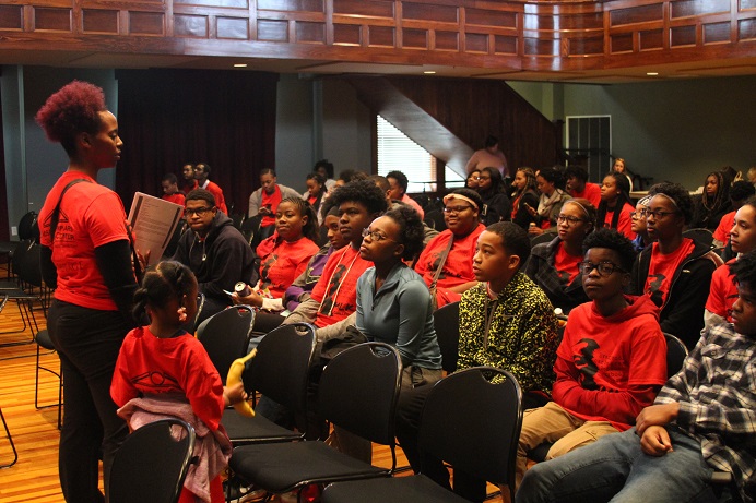 womanandyounggirlstandinginfrontofgroupspeaking