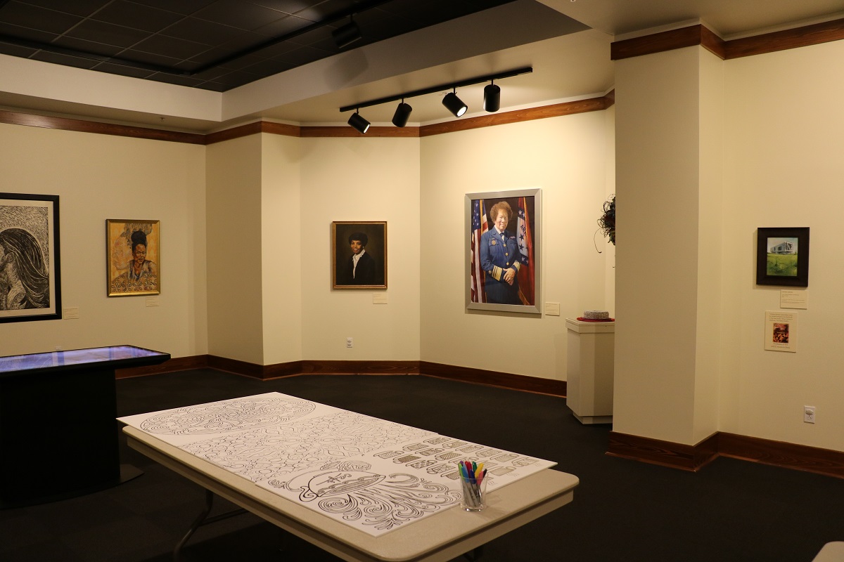 museumexhibithallwithtableinthemiddlewithlargecoloringsheetandSharpiemarkers