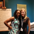twowomenstandingtogetherandsmilingbyexhibit