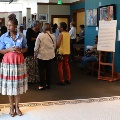 womanstandingontiledfloorwithexhibitsgiftshopandcrowdsofpeoplebehindher