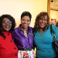 womenstandingtogethersmilingatexhibit