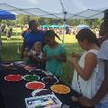 adultsandchildrenundertentmakingnecklaces