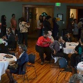 roundtablesineventhallwithcrowdsofpeoplestandingaroundandsittingatthem