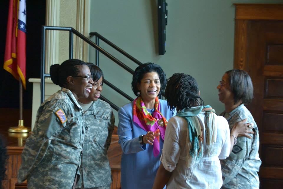 militarywomeninuniformtalkingwithwomaninbluedressandwomaninscarf
