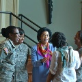 militarywomeninuniformtalkingwithwomaninbluedressandwomaninscarf