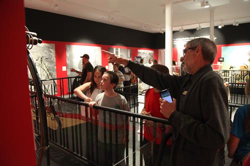 man pointing at wall with children standing around